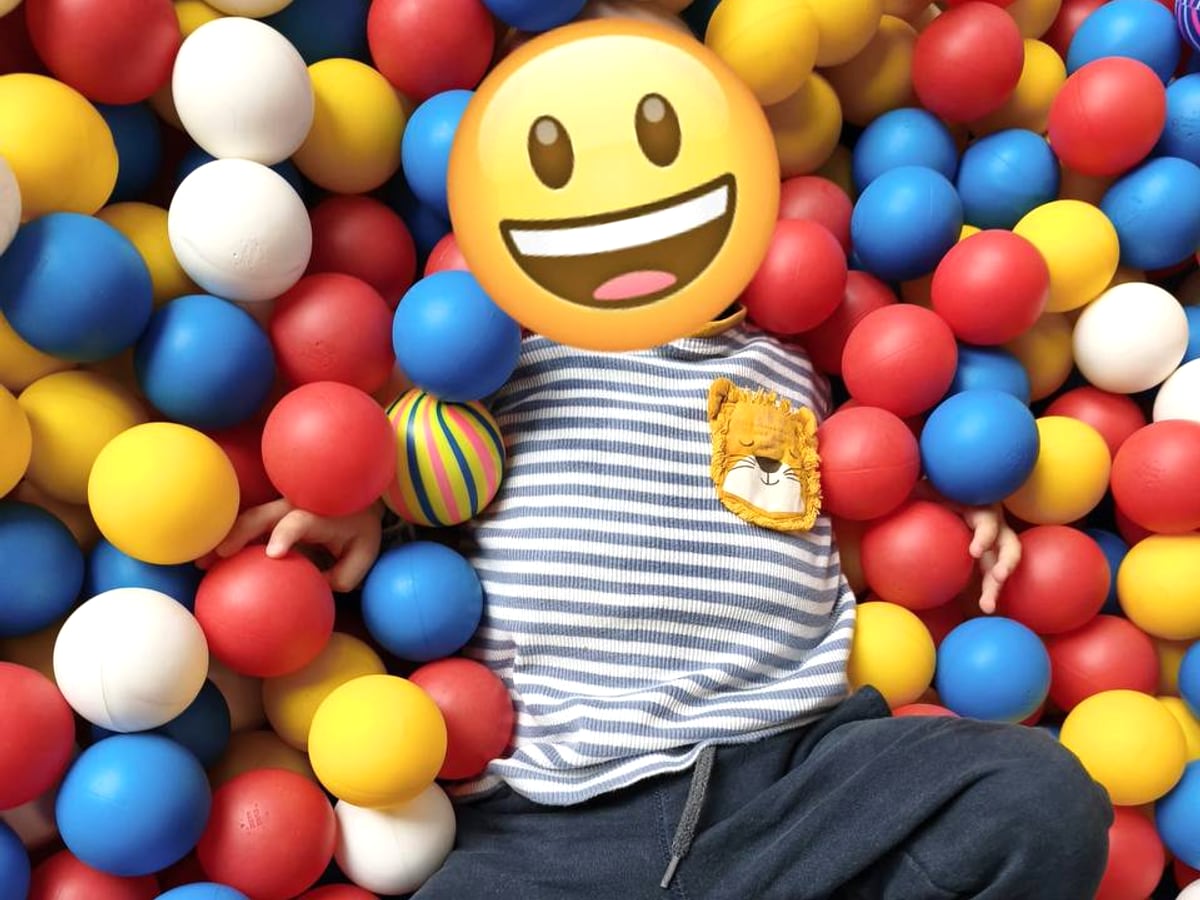 Kind spielt im bunten Bällebad, Gesicht unkenntlich gemacht